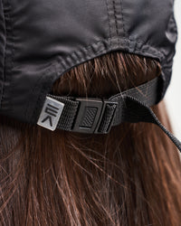Product-focused close-up of woman wearing EVOActive Unisex Core Run Cap highlighting the adjustable strap with logo on the strap