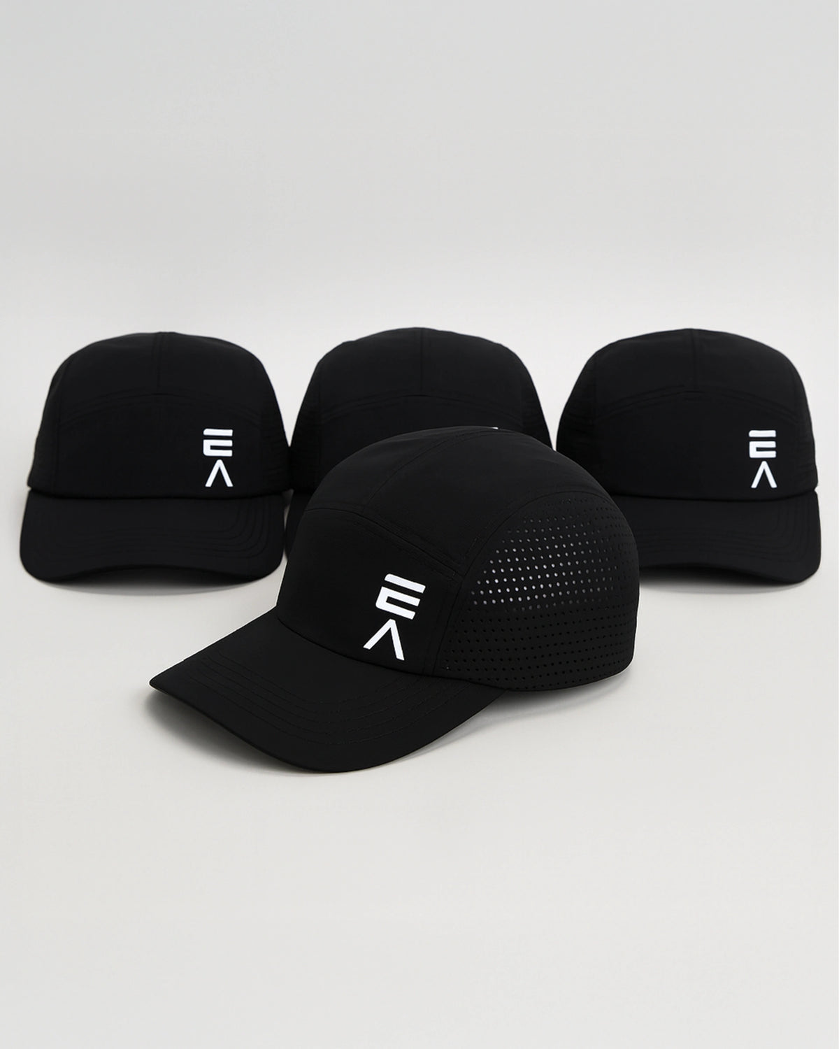 Studio product image of four midnight black EVOActive Unisex Core Run Caps, all showing the front, with one cap in front at a slight side angle and logos visible against a bright background