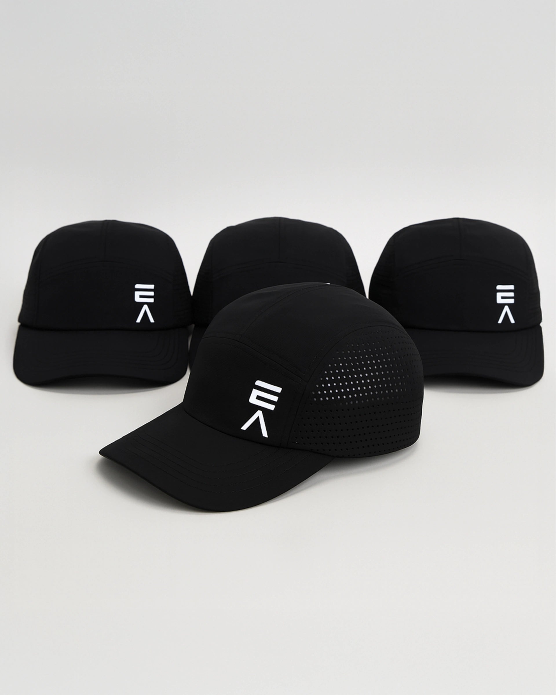Studio product image of four midnight black EVOActive Unisex Core Run Caps, all showing the front, with one cap in front at a slight side angle and logos visible against a bright background