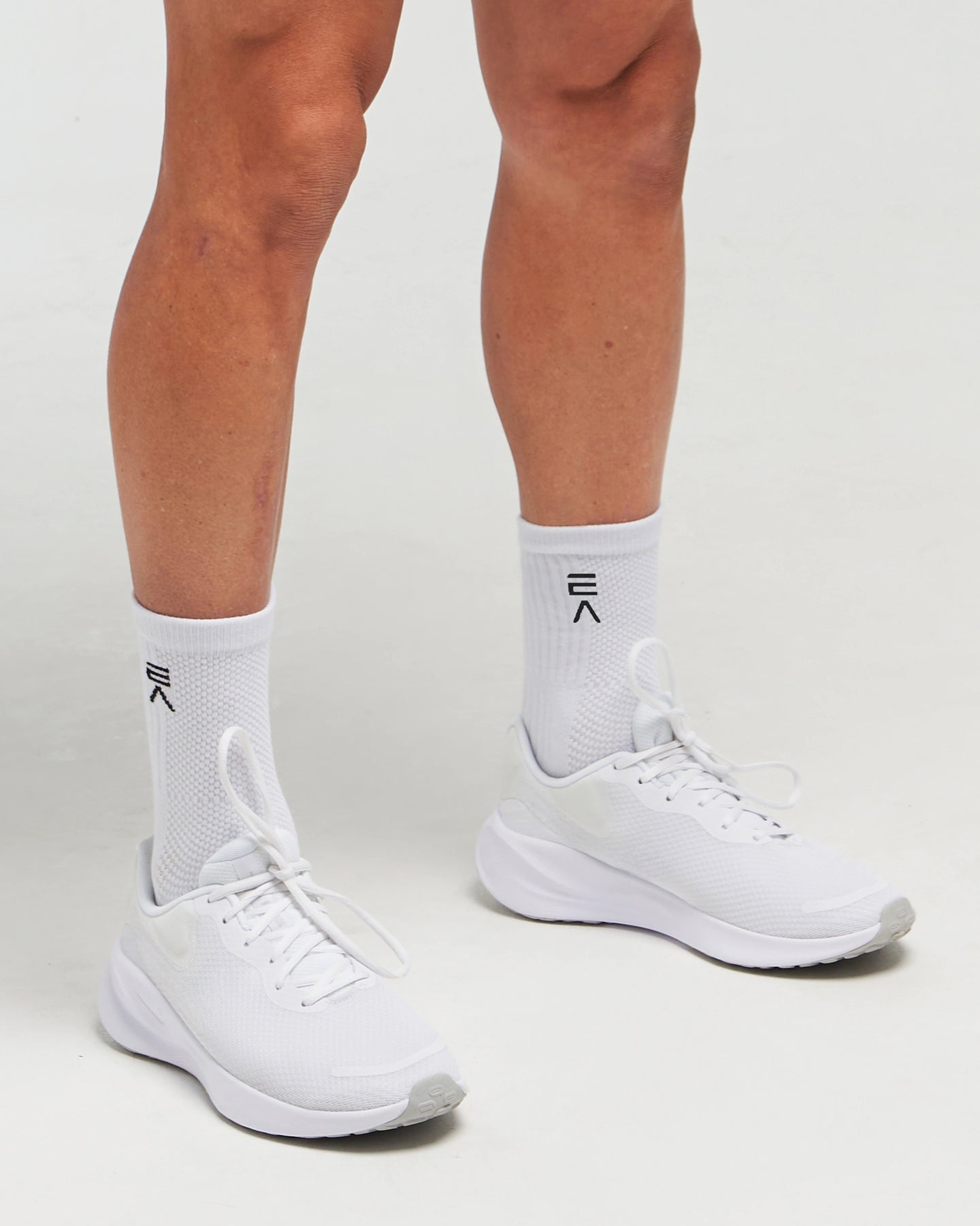 Person wearing Evo Ice white EVOActive Elevate Mid Sock with logo visible, paired with white shoes against a white background