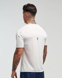 Back view of man wearing Evo Ice white EVOActive Men’s Aero Tee in a slight side pose with logo visible against a bright background
