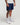 Front view of man wearing eclipse navy EVOActive Men’s FlexMotion Shorts in a slight side pose with logo visible on the shorts against a bright background