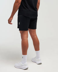 Lower half back view of man wearing midnight black EVOActive Men’s FlexMotion Shorts with logo visible