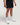 Lower half view of man wearing midnight black EVOActive Men’s FlexMotion Shorts in a slight side pose with front  and logo visible