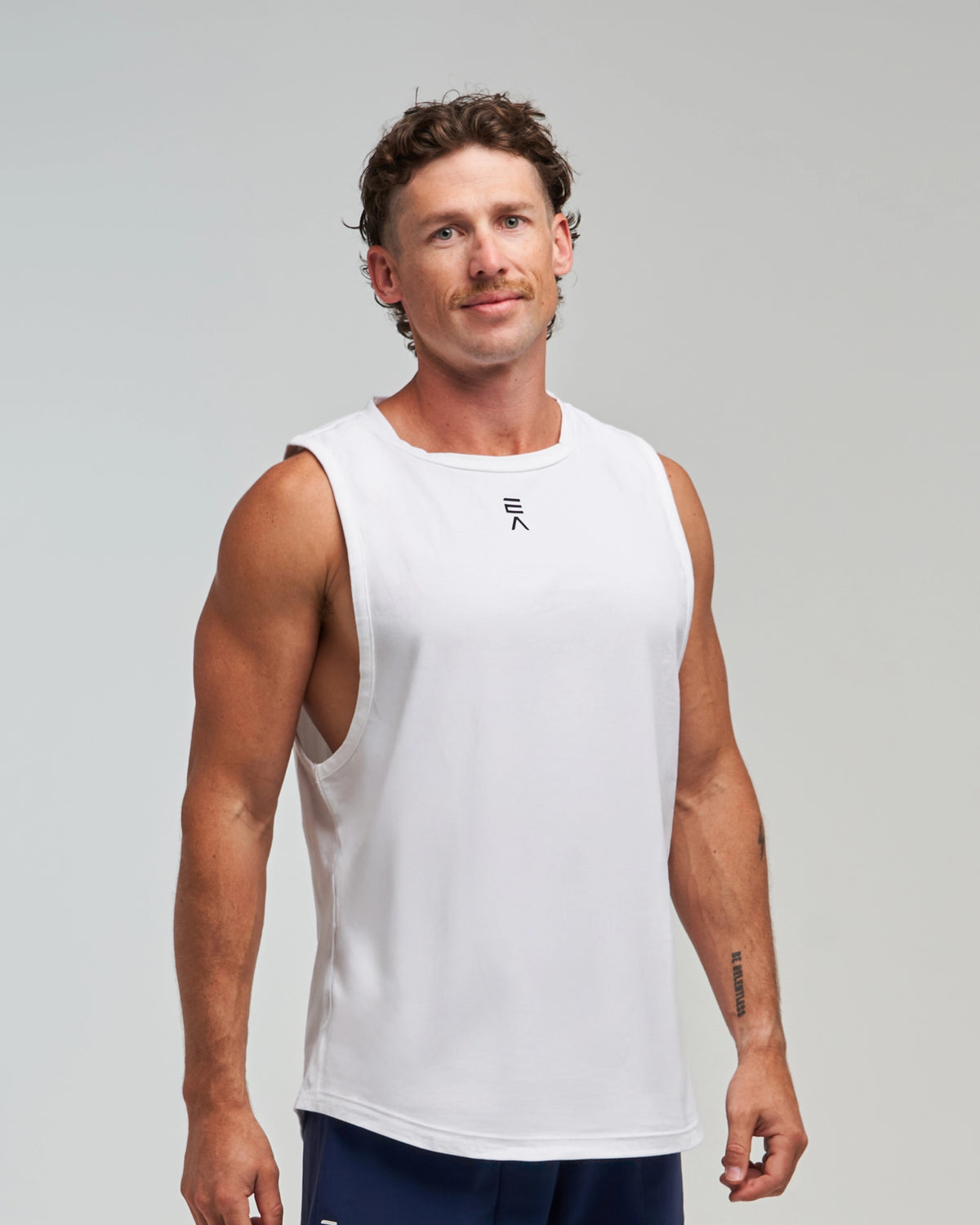 Half-body front view of man wearing Evo Ice white EVOActive Men’s Flex Singlet with logo visible
