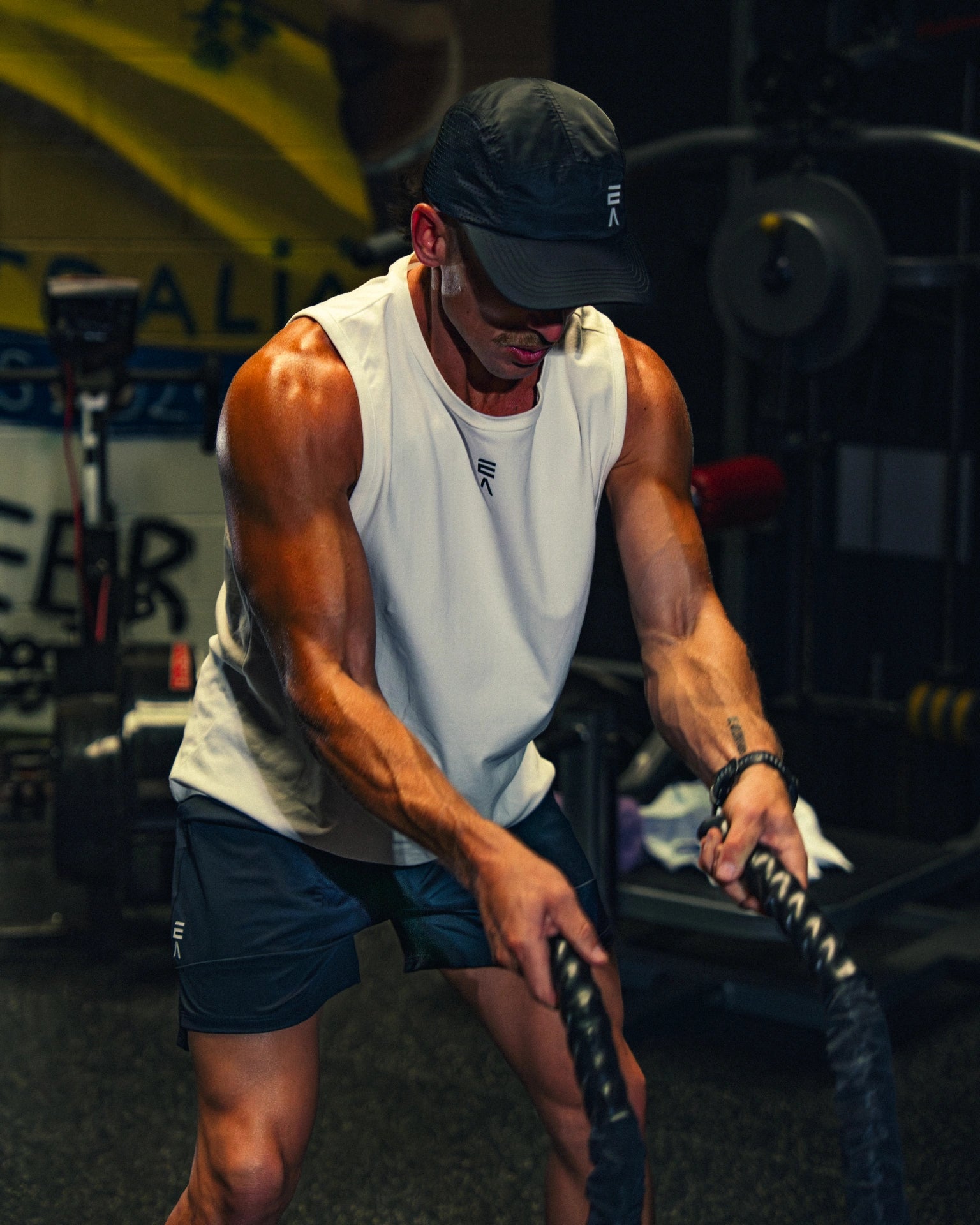 Man wearing Evo Ice white EVOActive Men’s Flex Singlet in gym action with logo visible