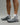 Person wearing Evo Ice white EVOActive Sprint Low Sock with logo visible, paired with grey shoes against a bright studio background
