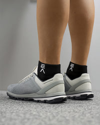 Back and side view of midnight black EVOActive Sprint Low Sock with logo visible against a bright studio background