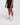 Half-body side pose with front visible of man wearing midnight black Unisex Aero Run Short against a bright background