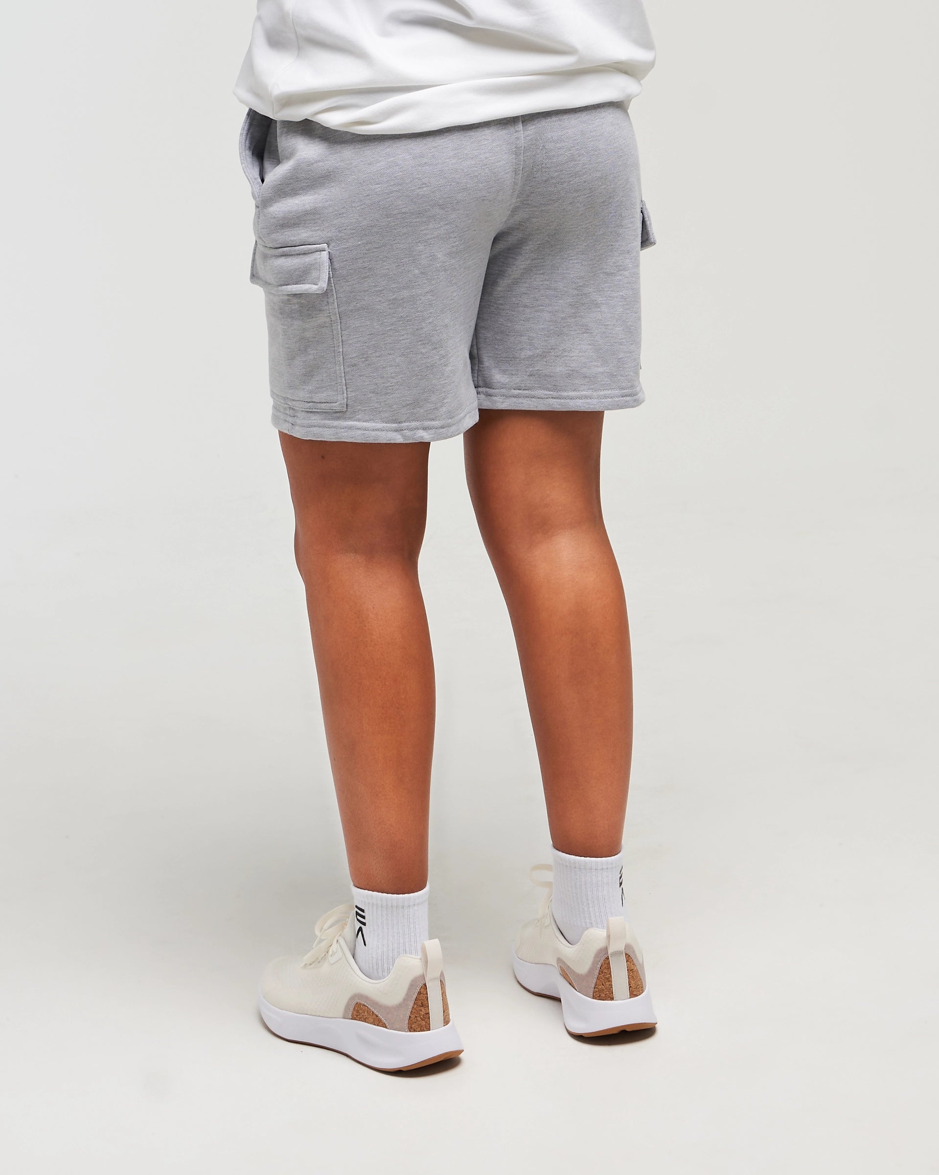 Lower-body back view of woman wearing Clouded Grey Unisex Classic Jogger Short against a white background
