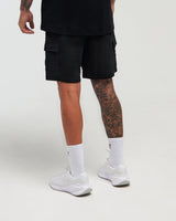 Lower-body back view of man wearing midnight black Unisex Classic Jogger Short against a bright background