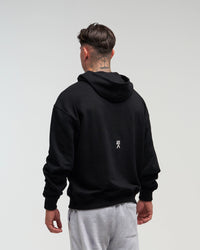 Back view of man wearing midnight black EVOActive Unisex Classic Pullover Hoody with logo visible on the garment against a bright background