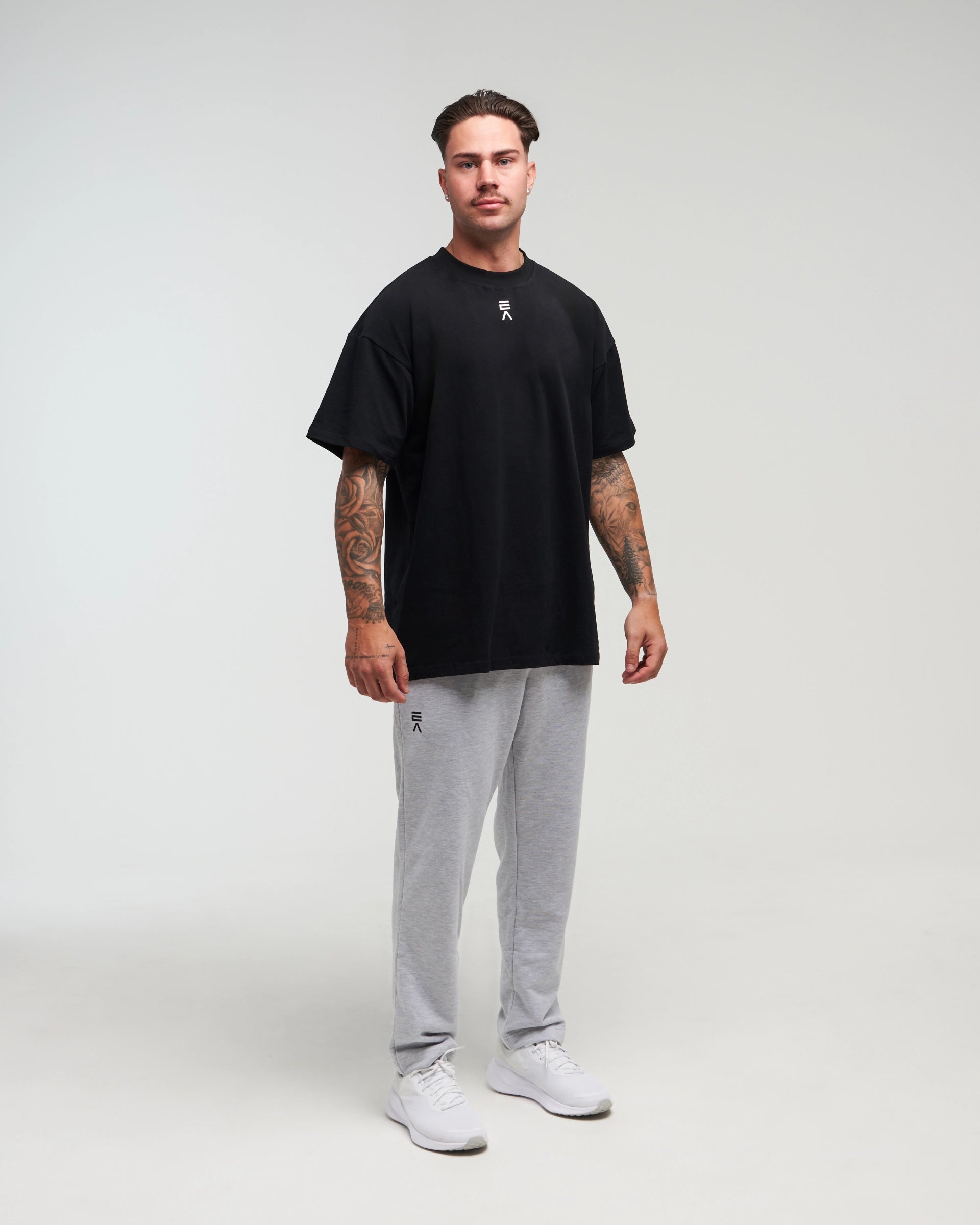 Full body view of man wearing clouded grey Unisex Classic Straight-Leg Jogger Pant against a bright background