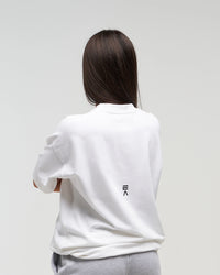 Back view of woman wearing Evo Ice white EVOActive Unisex Classic Tee with logo visible against a bright plain background