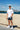 Full body view of man wearing Evo Ice white EVOActive Unisex Classic Tee standing on a beach