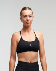 Front view of woman wearing midnight black EVOActive Women’s Elevate Open Back Sports Bra with logo visible
