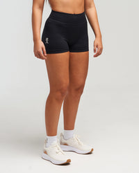 Front side view of woman wearing midnight black EVOActive Women’s Elevate Short with logo visible
