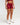 Front view of woman wearing red EVOActive Women’s Elevate Short in a slight side pose with logo visible