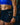Woman wearing black EVOActive Women’s Motion Pocket Short front view, logo visible and mobile in pocket against dark blurred background