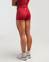 Back view of woman wearing heritage red EVOActive Women’s Motion Short in a slight side pose with logo visible