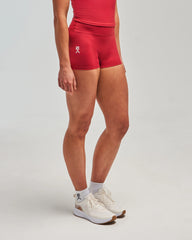 Front view of woman wearing heritage red EVOActive Women’s Motion Short in a slight side pose with logo visible